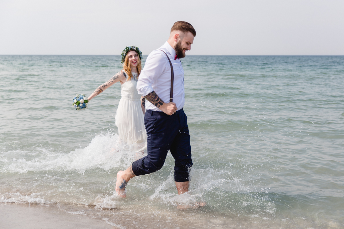 Brautpaar rennt beim Shooting durch die Ostsee.